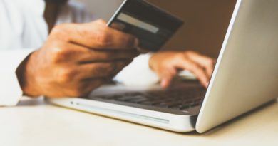 Un homme effectuant des achats à partir de son ordinateur avec sa carte bancaire.